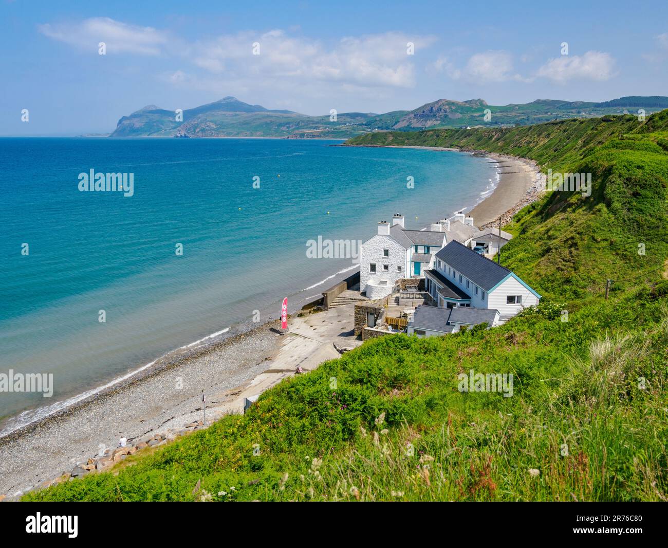 House and cottages on Morfa Nefyn beach looking towards Yr Eifl on the Lleyn Peninsula in North Wales UK Stock Photo