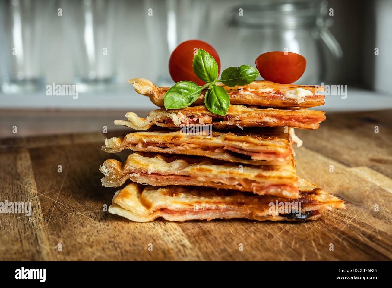 Hybrid food - pizza waffle with tomato sauce, pepperoni, olives and parmesan cheese Stock Photo