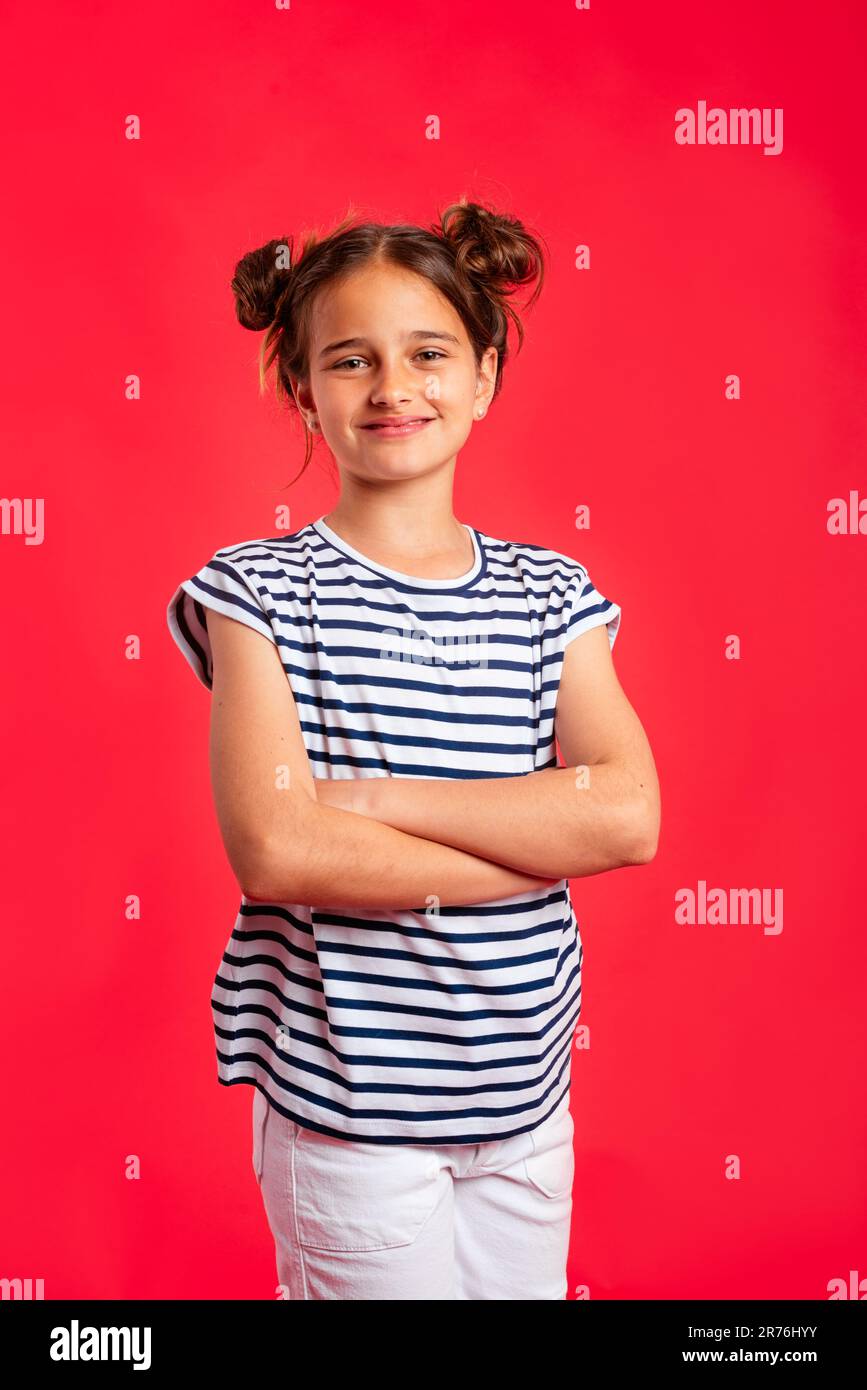 Cute preteen girl in casual striped clothes with folded arms smiling ...