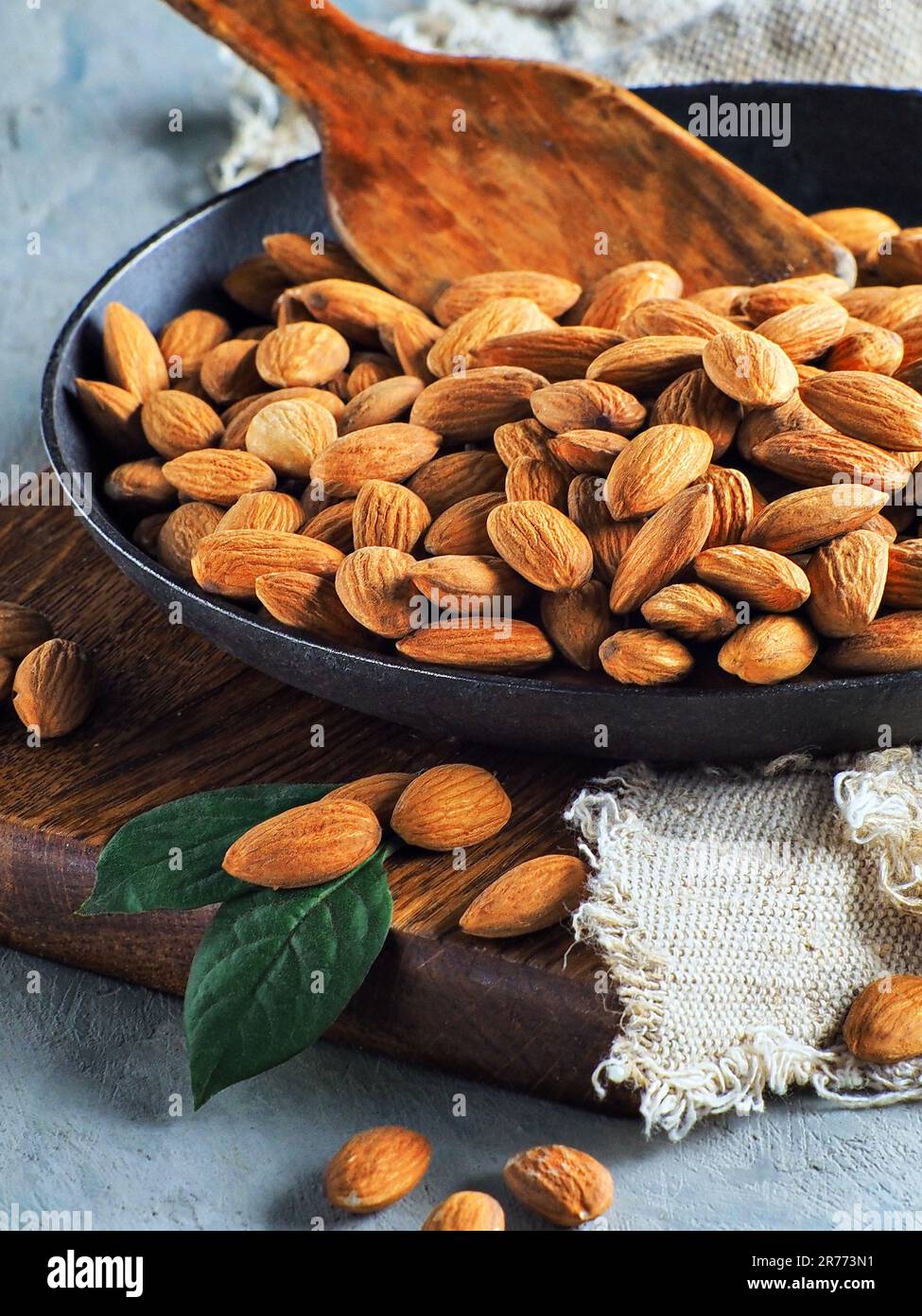 Selected peeled almond kernels lie in a black frying pan. Still life for promotional products for marketplaces or online stores. Useful nut for a healthy balanced diet. Stock Photo
