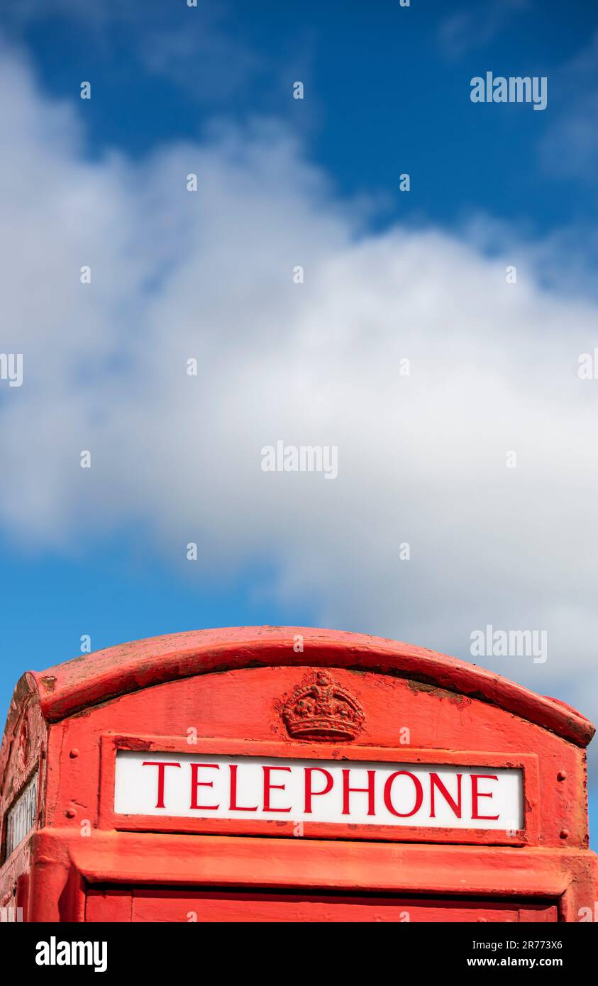 An iconic red British telephone box contrasted against a blue sky and