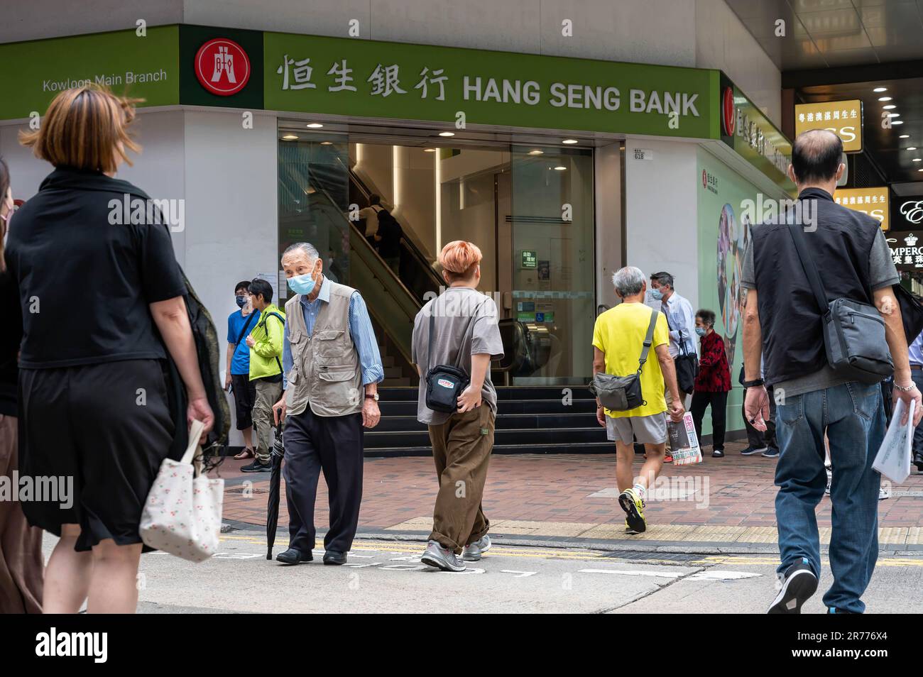 Pedestrians walk past the Hong Kongbased banking and financial