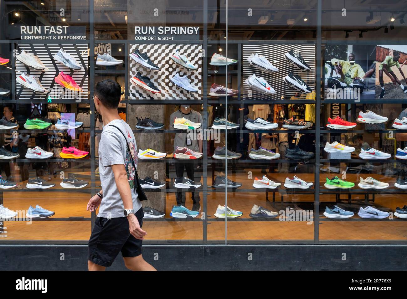 A pedestrian walks past the American multinational sports clothing brand,  Nike, store displaying shoes for sale in Hong Kong Stock Photo - Alamy