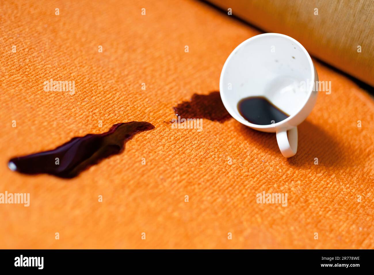 Spilled coffee on a white carpet. Stock Photo