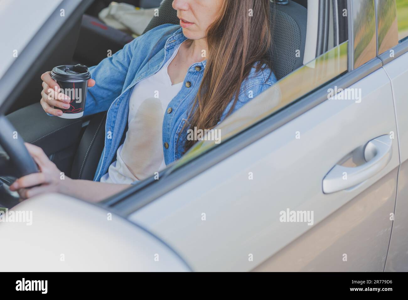 Coffee stain. Unrecognizable girl spilling coffee or tea on herself. Spoiled clothes. Concept of cleaning stains on clothes Stock Photo