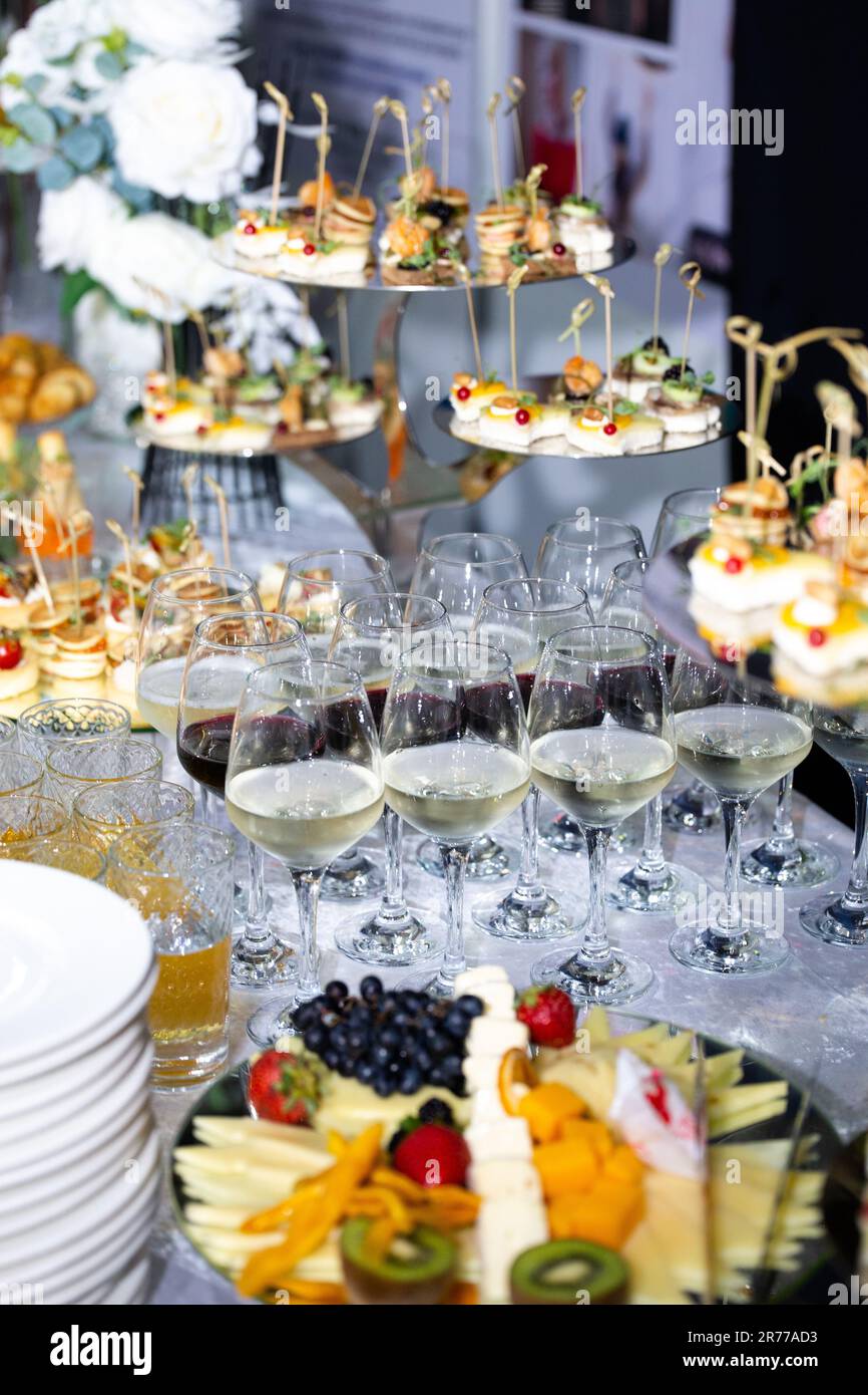 glasses of white wine and various snacks on the buffet table at the event Stock Photo Alamy