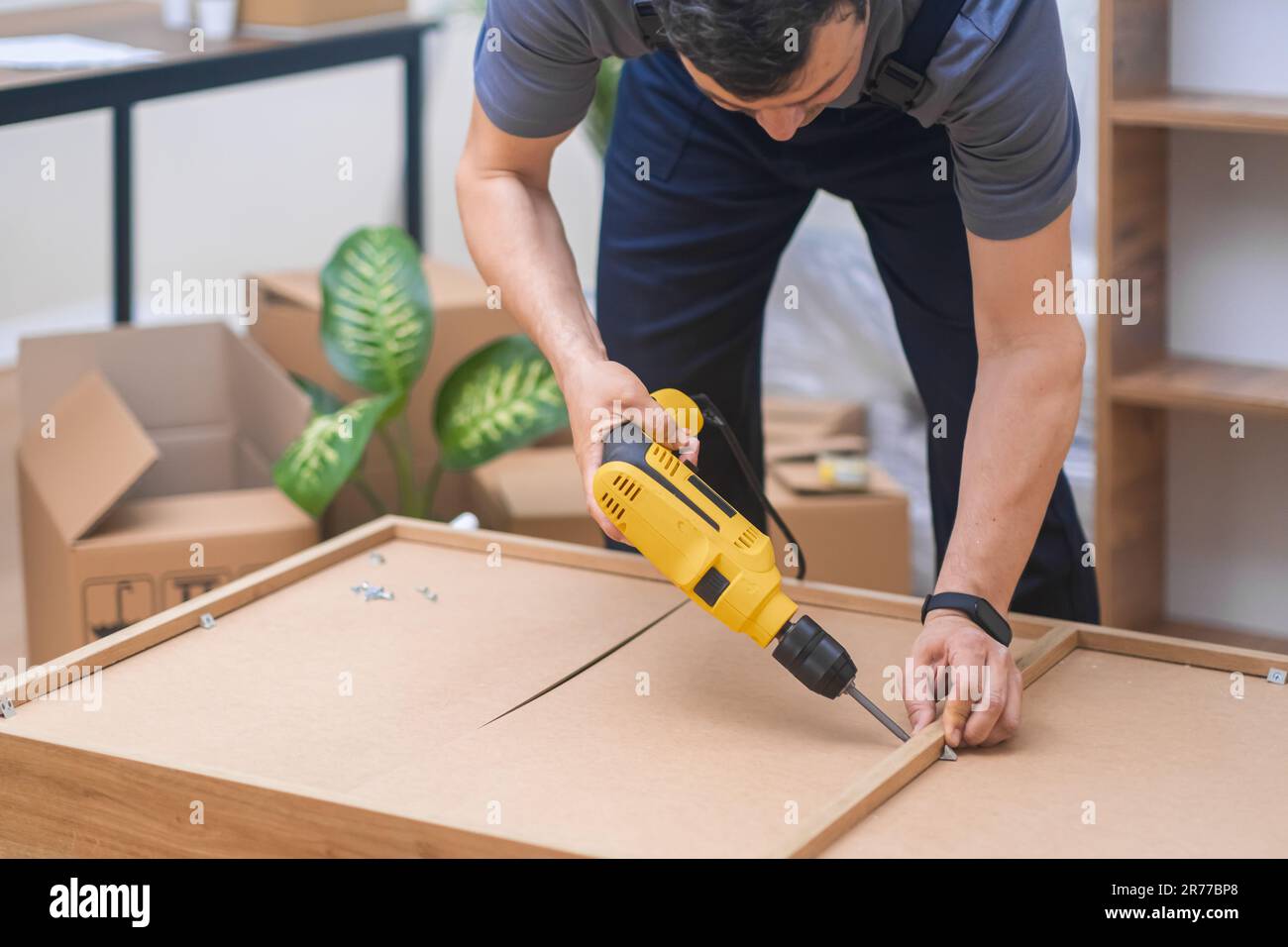 Furniture manufacturing industry craftsman uses drilling machine to