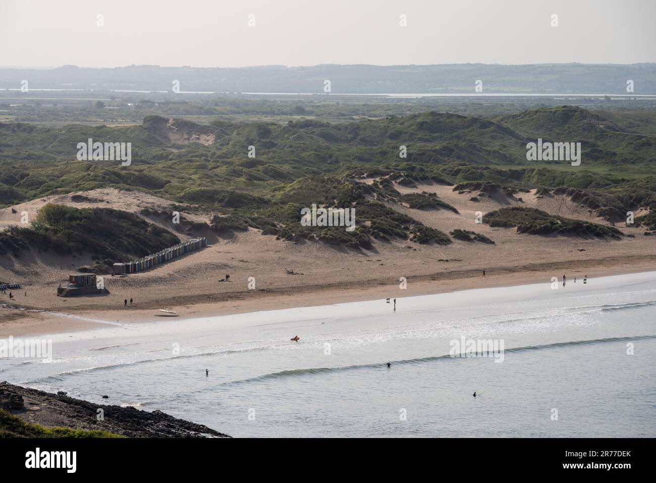 Surfers and walkers enjoy the beach at Braunton Sands in North Devon, with the Braunton Burrows dune system and River Taw estuary behind. Stock Photo