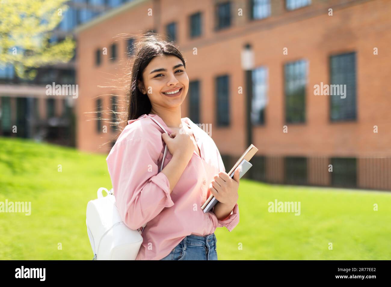 Portrait of glad lady student with books posing outdoors and smiling at  camera, ready for lesson in university campus Stock Photo - Alamy, image size:1300x956