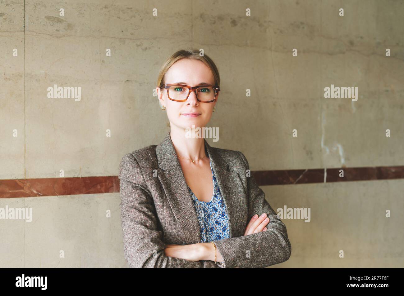 Portrait of young 35 year old woman wearing brown eyeglasses and jacket Stock Photo