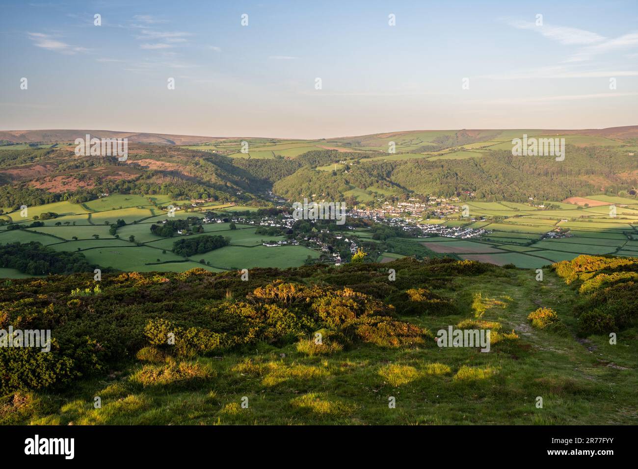 Morning sun shines on the hills of Exmoor above Porlock village in West Somerset. Stock Photo
