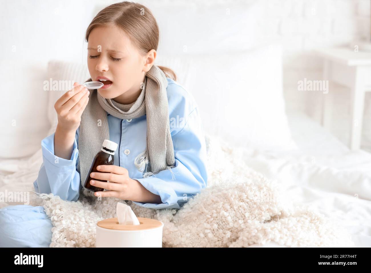 Ill little girl taking cough syrup in bedroom Stock Photo Alamy