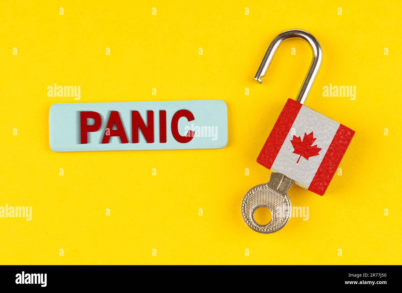 On a yellow surface, an open lock with the image of the flag of Canada ...