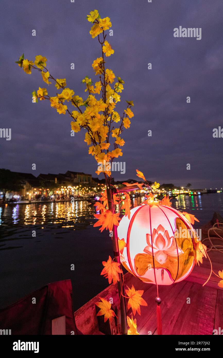 Boat at night in the river with lantern. Hoi An night market in the background. Vietnam Stock Photo