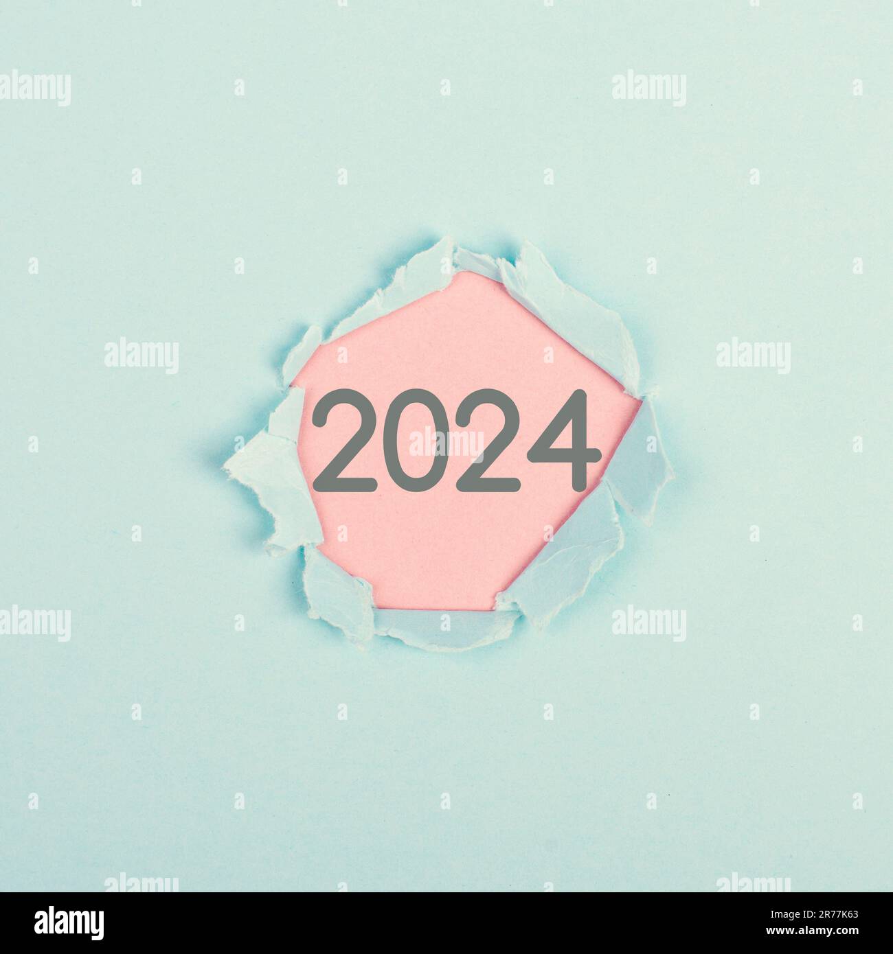New year 2025 stands behind ripped paper, calendar date, end of the