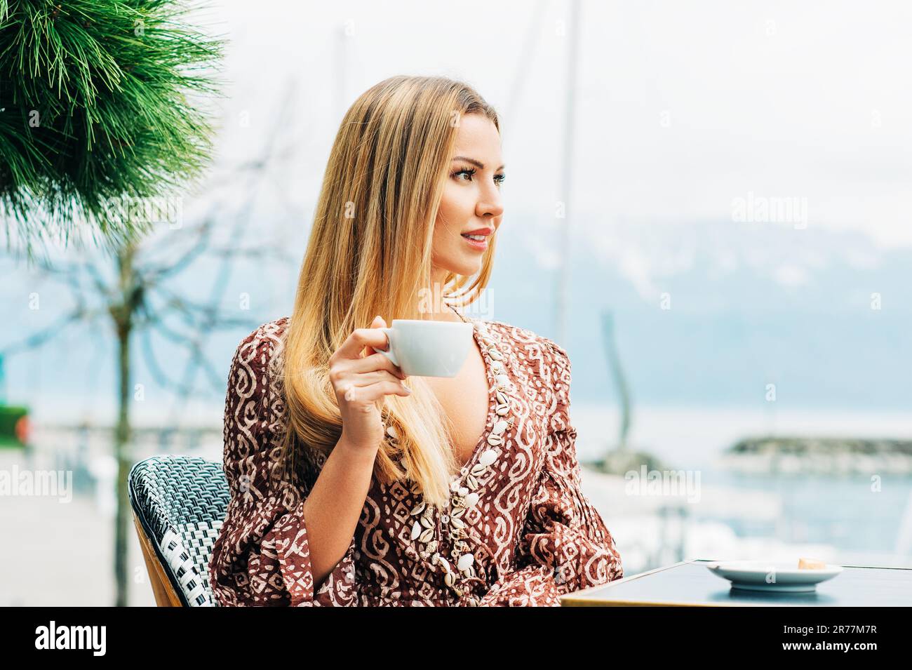 Outdoor portrait of beautiful woman resting in cafe with cup of coffee ...