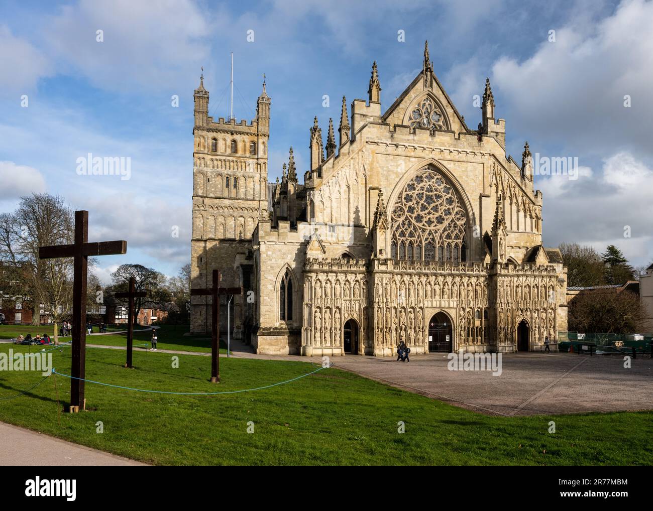 Sun shines on the ornate gothic west face and Norman north tower of Exeter Cathedral in Devon. Stock Photo