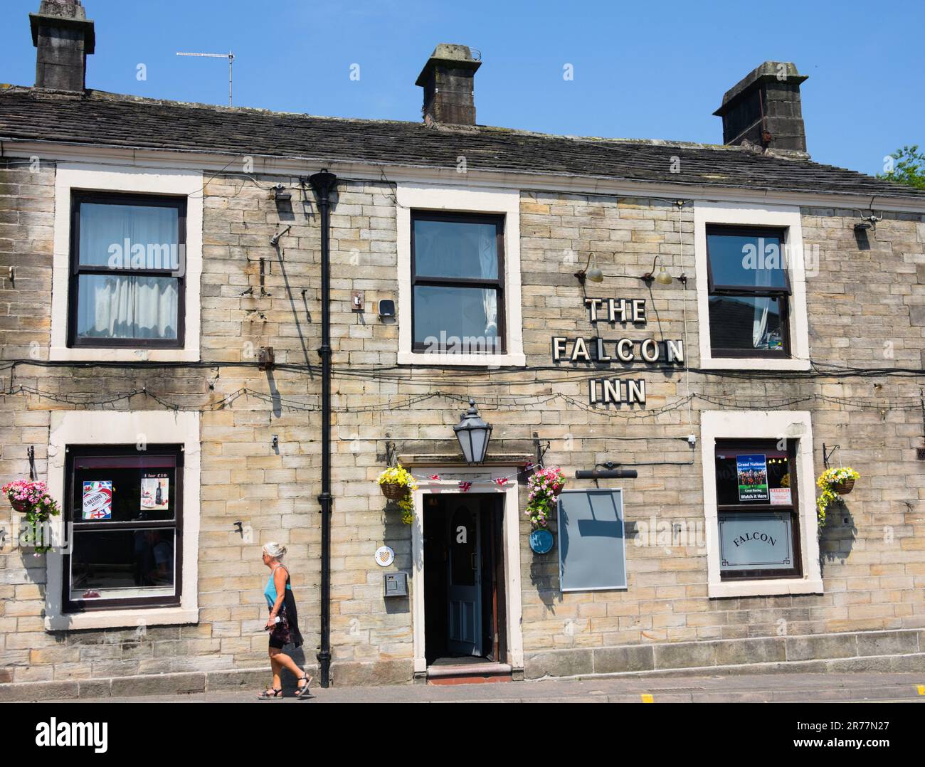 A person walks past exterior of the Falcon Inn in Littleborough, Greater Manchester, UK. Stock Photo