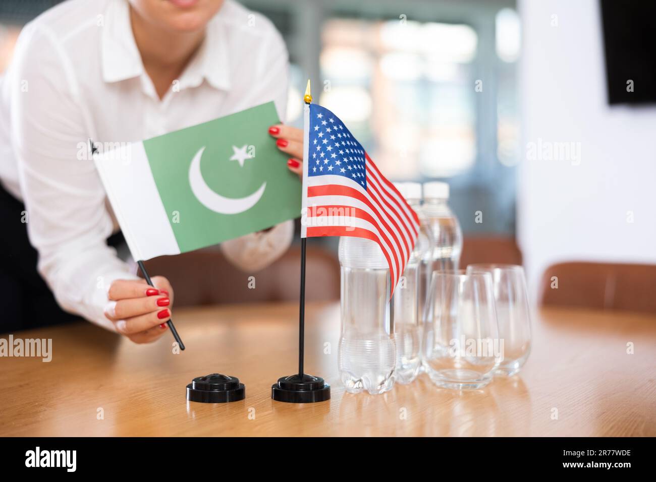 Flags of Pakistan and USA stand on negotiating table in office Stock Photo