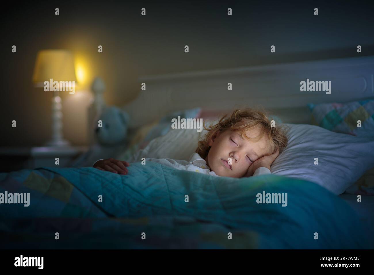 Child sleeping in dark bedroom. Little boy napping. Healthy night rest