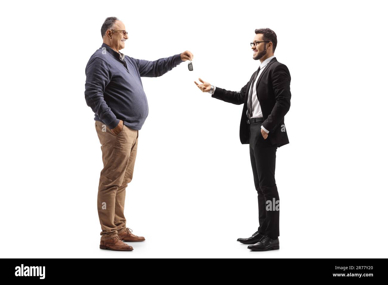 Mature man handing car keys to a businessman isolated on white background Stock Photo