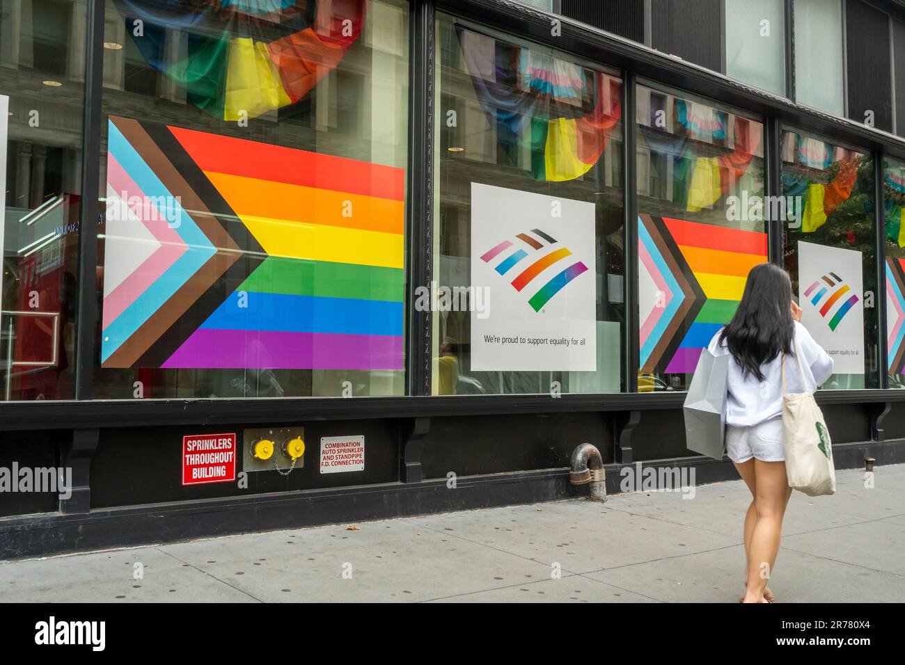 The window of a Bank of America branch in the Flatiron neighborhood in New York displays the Progress Pride Flag and rainbow colors for their support of Gay Pride, seen on Sunday, June 11, 2023.  (© Richard B. Levine) Stock Photo