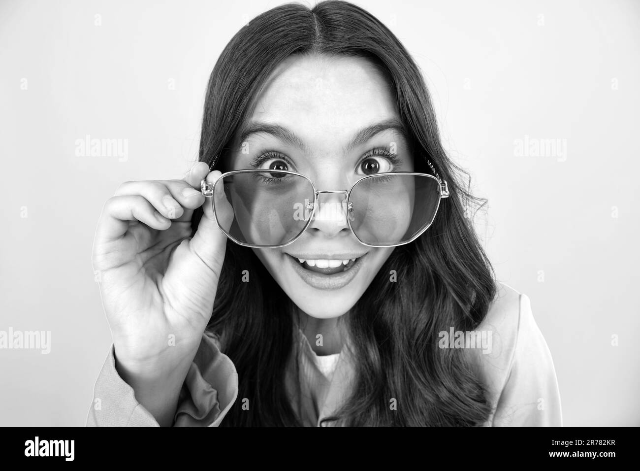 Shocked surprised teenager girl. Happy face, positive and smiling emotions of teenager girl. Teenager child wear sunglasses, looking squinting. Kids g Stock Photo