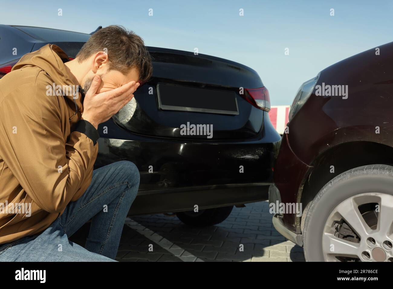 Stressed man near car with scratch outdoors. Auto accident Stock Photo