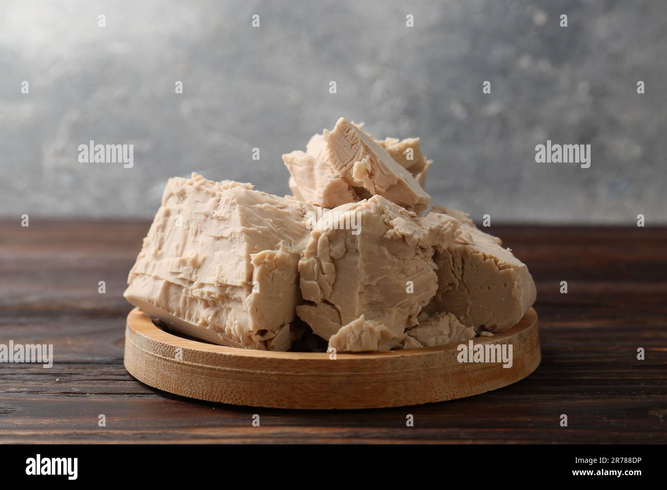 Pieces of compressed yeast on wooden table Stock Photo