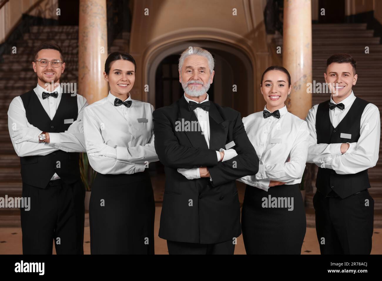 Group of young trainees with teacher in hotel. Professional butler Group of young trainees with teacher in hotel. Professional butler