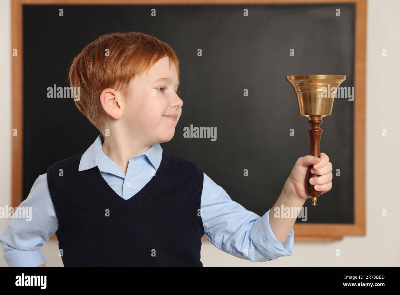 Cute little boy ringing school bell in classroom Stock Photo Alamy