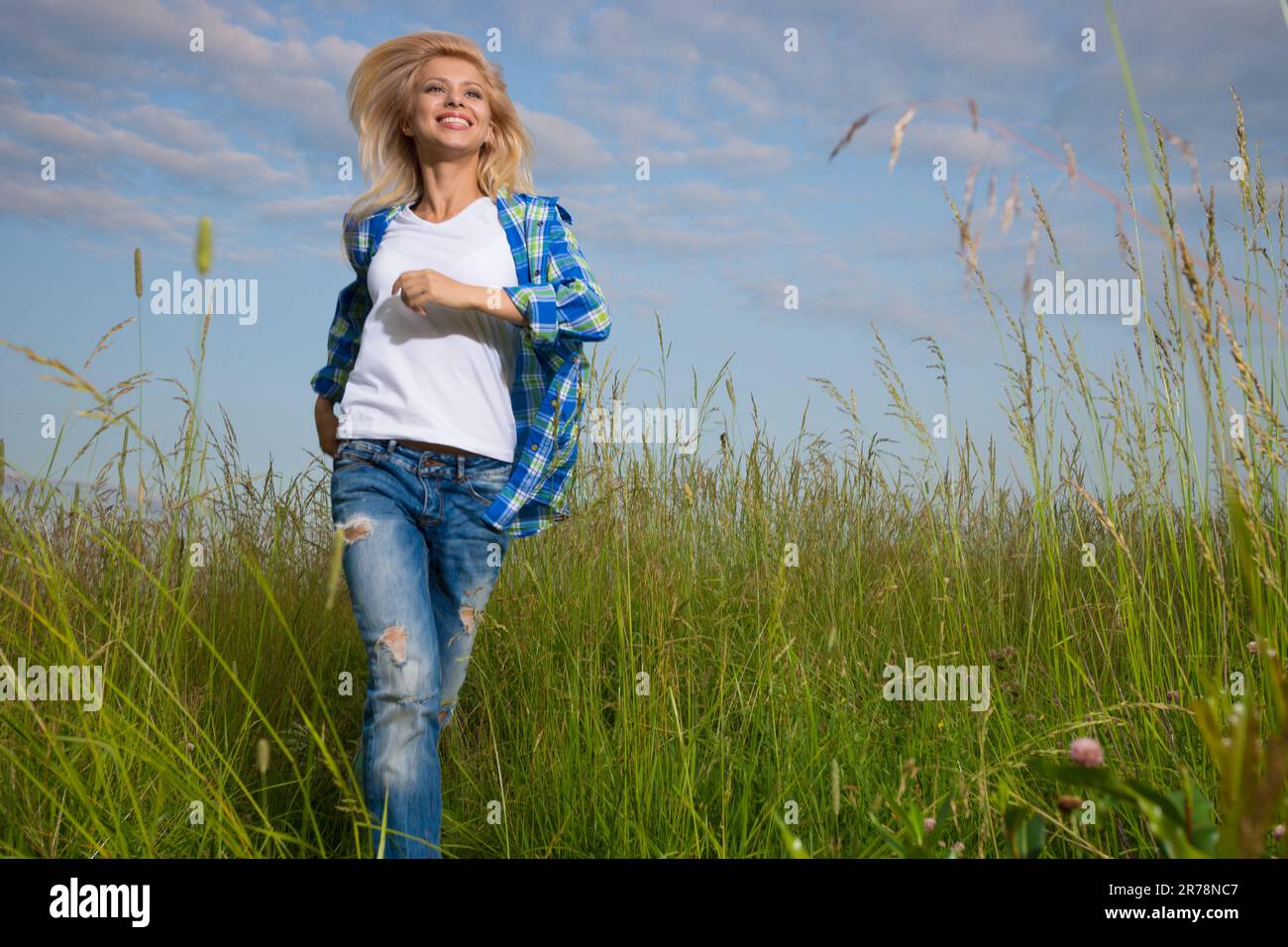 Pretty young woman walk in grass field Stock Photo Alamy