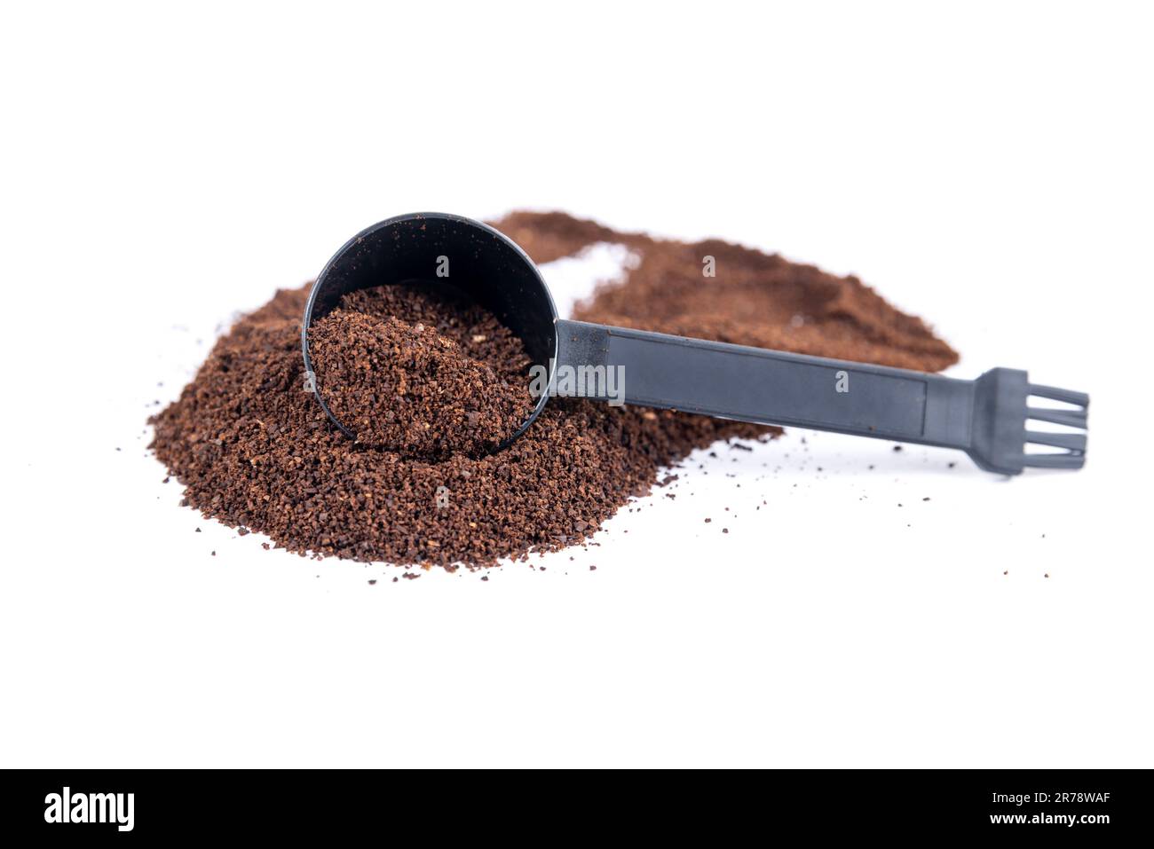 Serving measuring scoop full of coffee grounds scooped through a hill
