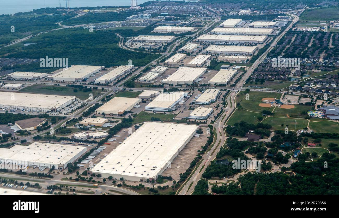 Oblique angle aerial view of large distribution centre logistics warehouse buildings on landing