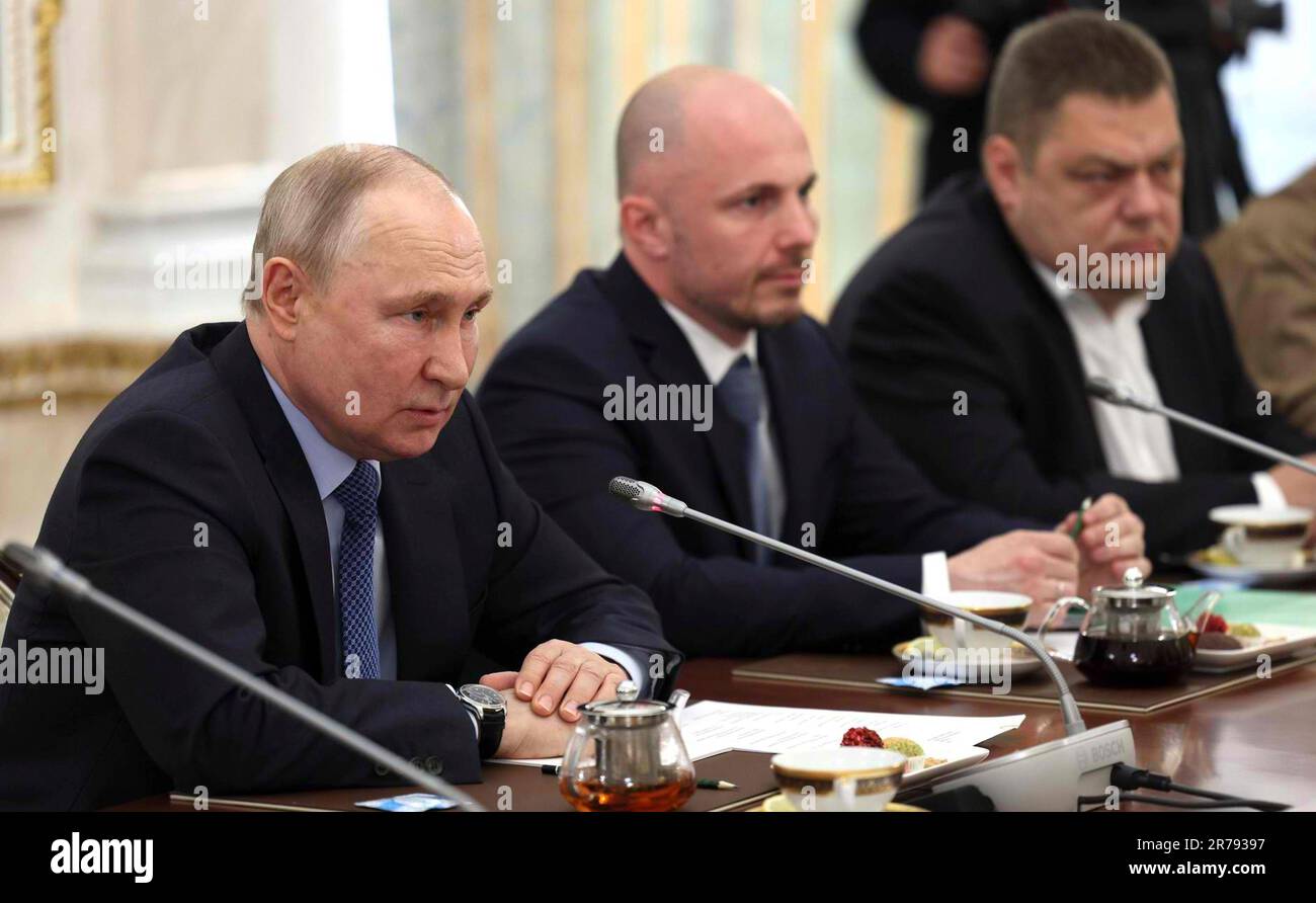 Moscow, Russia. 13th June, 2023. Russian President Vladimir Putin, left, holds a face-to-face meeting with Russian war correspondents at the Grand Kremlin Palace, June 13, 2023 in Moscow, Russia. From left: President Vladimir Putin, Andrei Filatov (Russia Today), and Ilya Ushenin (NTV Television Company). Credit: Gavriil Grigorov/Kremlin Pool/Alamy Live News Stock Photo