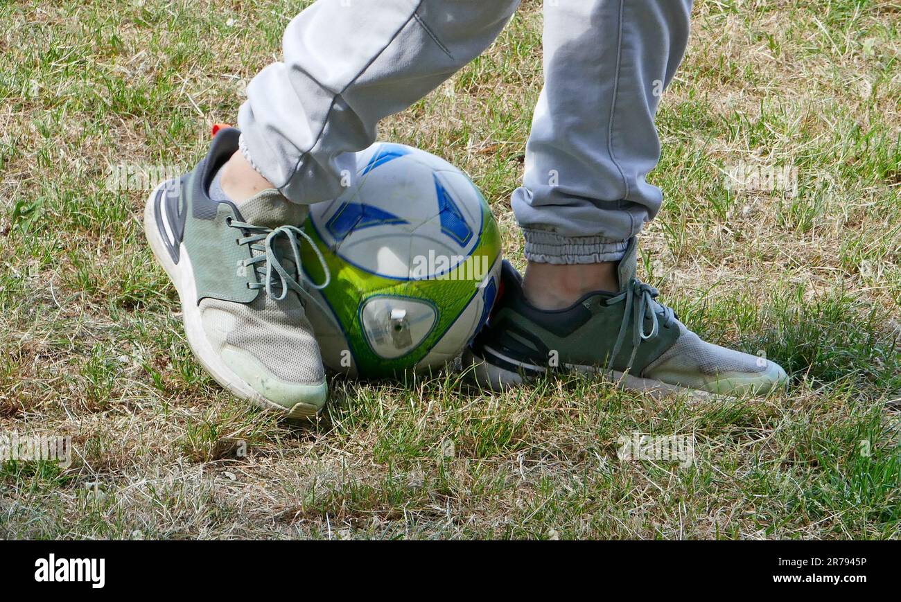 The legs of a boy who makes soccer exercises Stock Photo