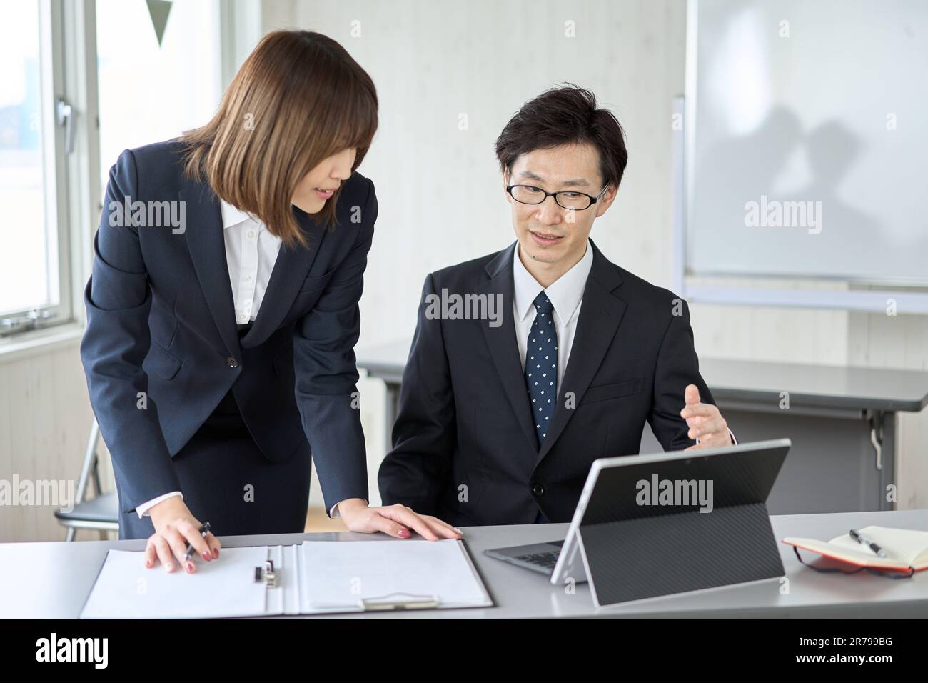 Asian businessman guiding his subordinate in his work Stock Photo