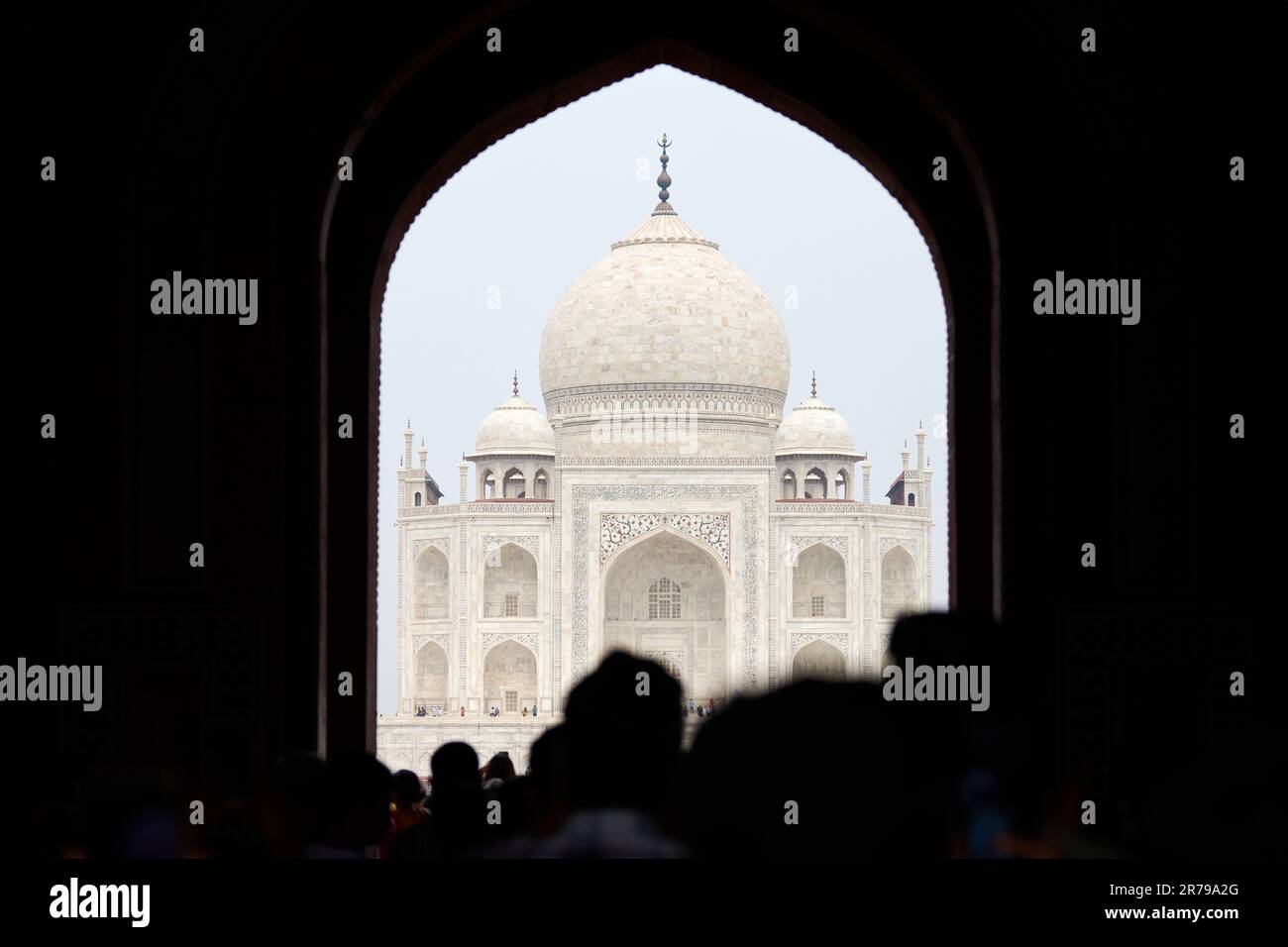 Archway of main gateway in Taj Mahal entrance with tourists silhouettes ...