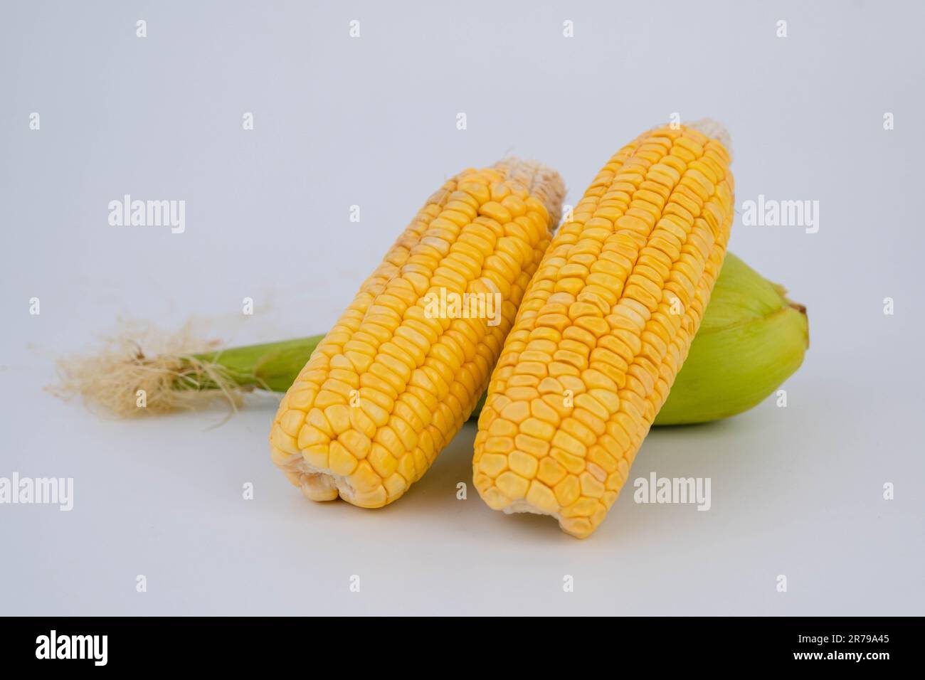 Corn on the cob with peeled corn on white background Stock Photo