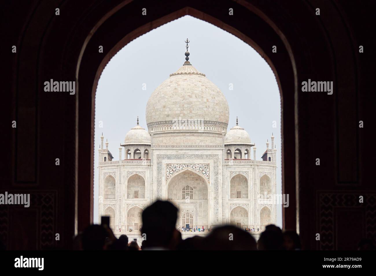 Archway of main gateway in Taj Mahal entrance with tourists silhouettes ...