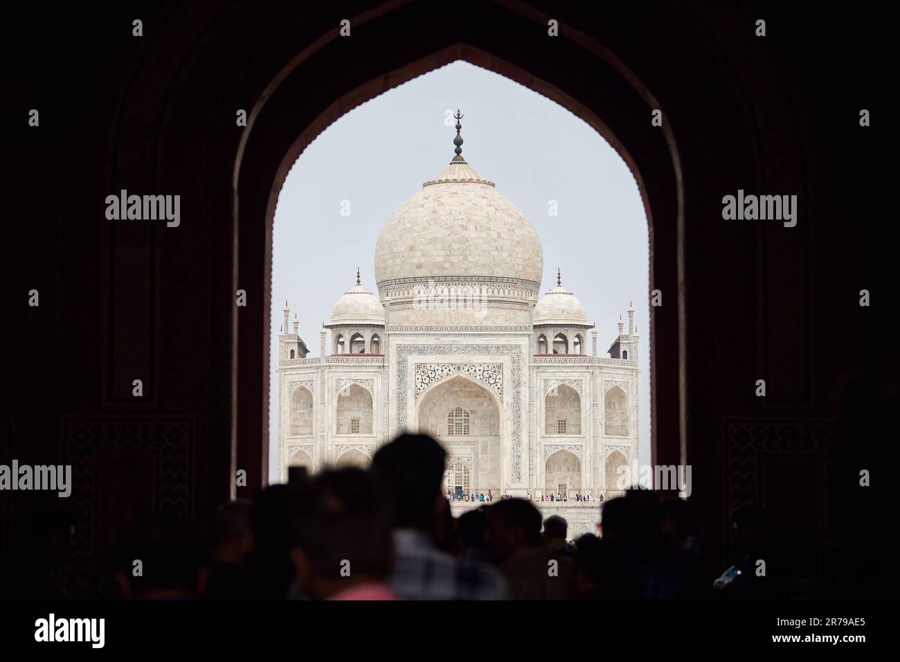 Archway of main gateway in Taj Mahal entrance with tourists silhouettes ...