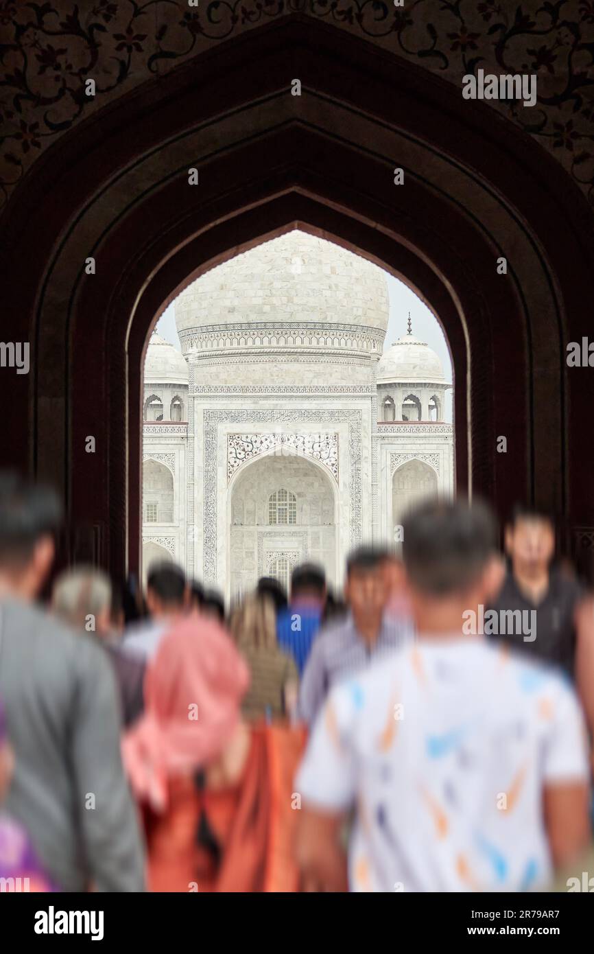 Archway of main gateway in Taj Mahal entrance with tourists silhouettes ...