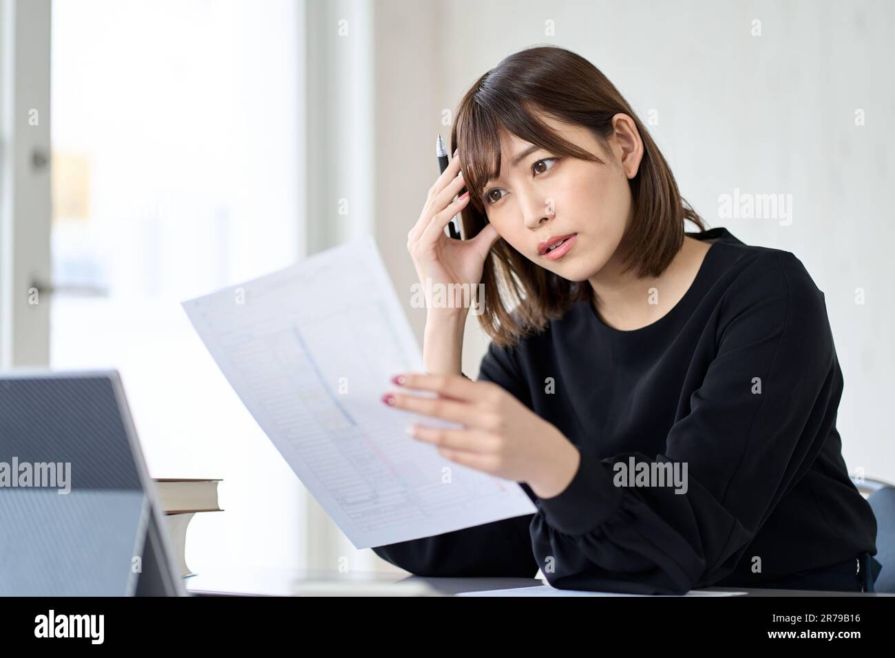 Asian woman worried about tax return Stock Photo