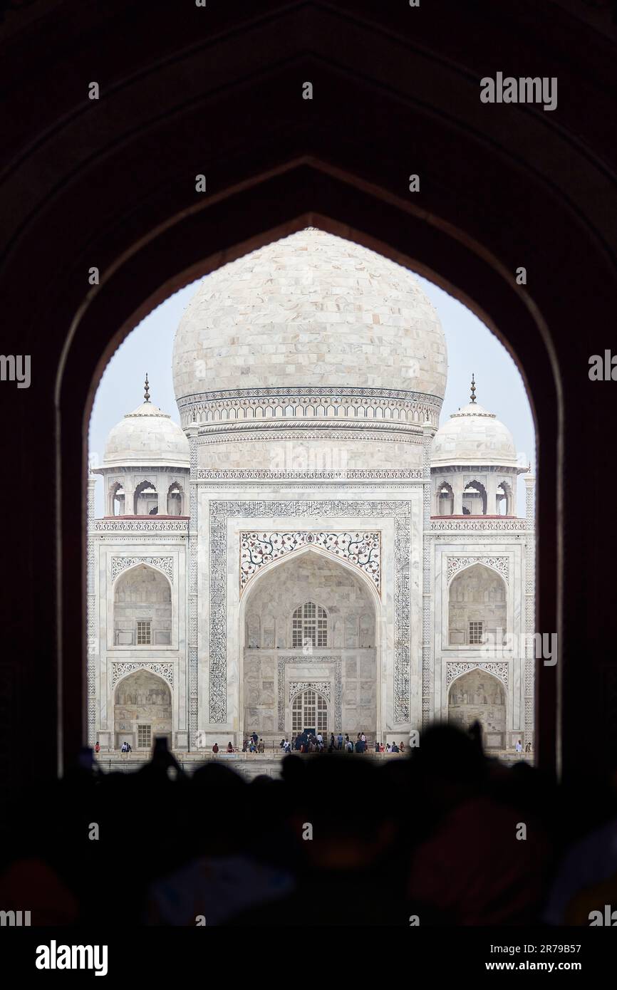 Archway of main gateway in Taj Mahal entrance with tourists silhouettes ...
