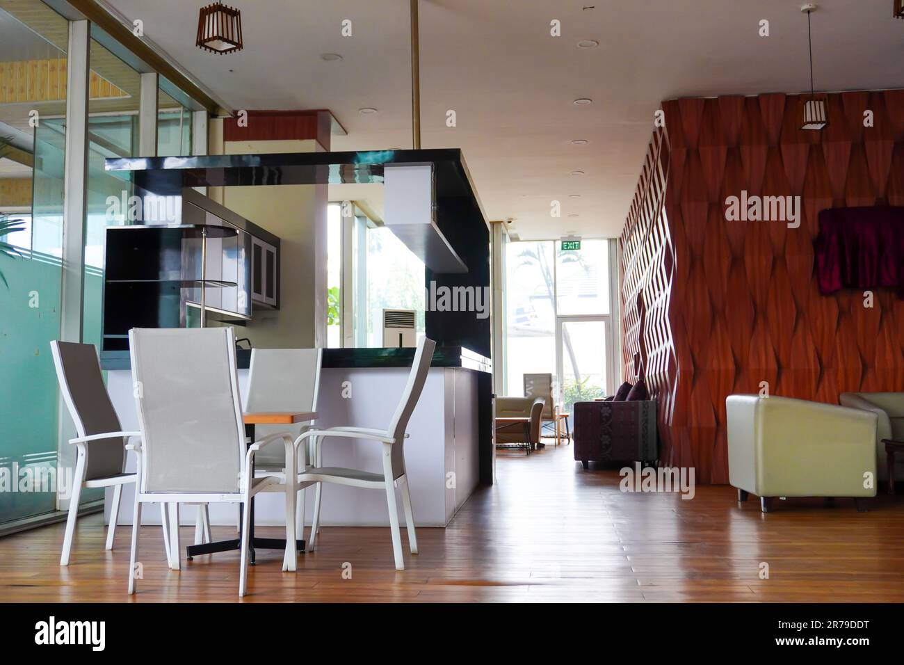 Charming dining chair and table decor with kitchen set, wooden floor, sofa, and exit door Stock Photo