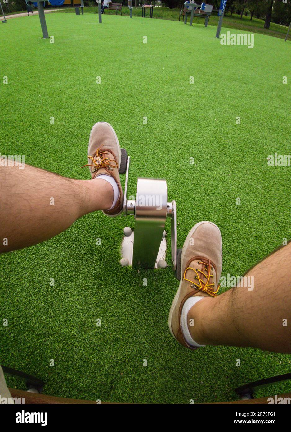 Mature man pedaling in outdoor gym park. Healthy active ageing concept Stock Photo