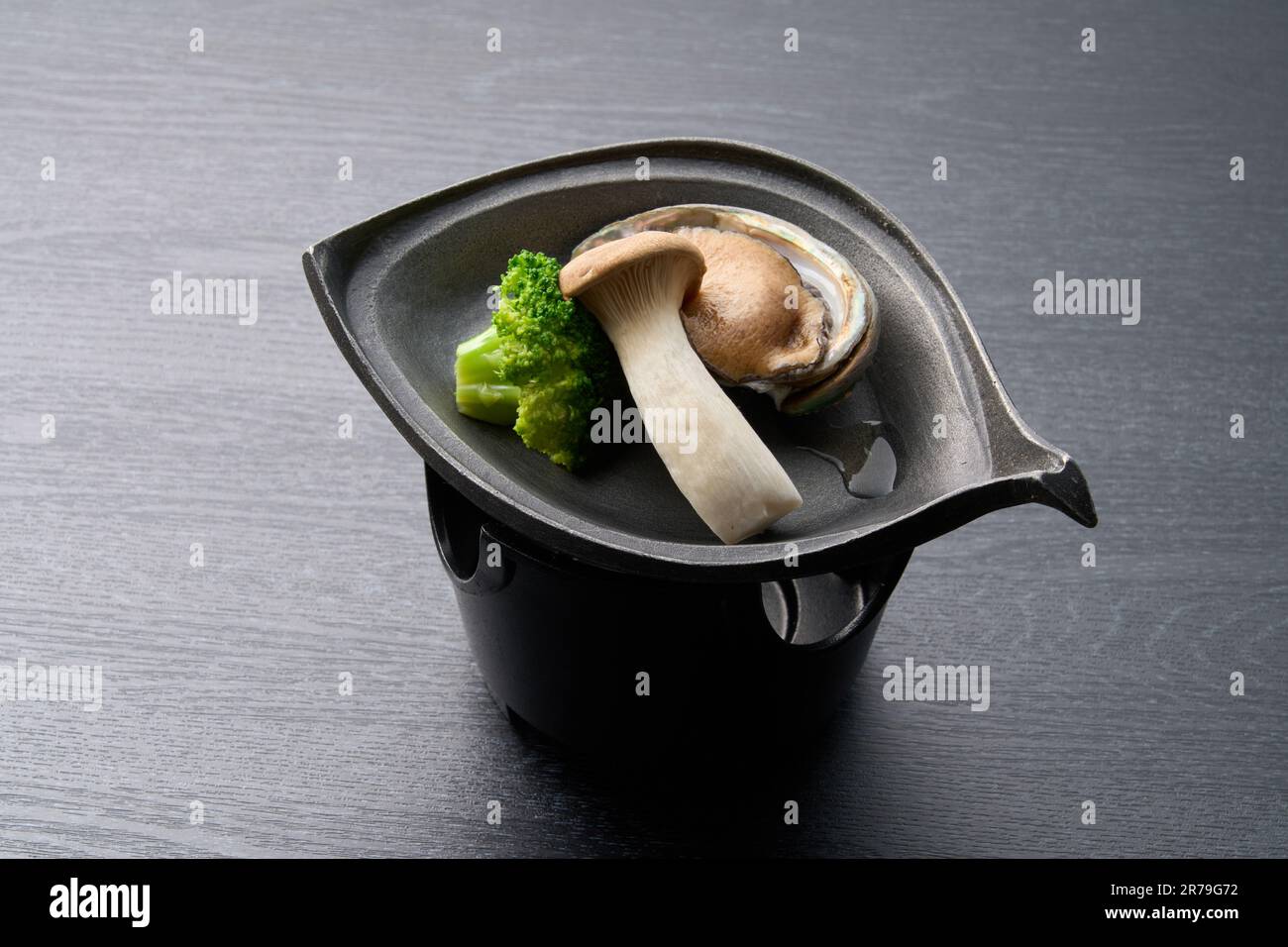 Japanese cuisine, abalone grilled on a ceramic plate Stock Photo