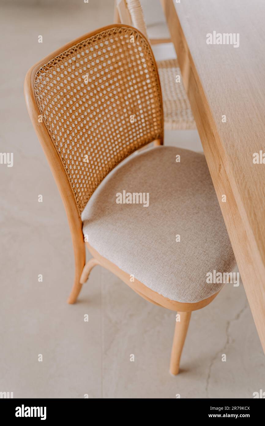 An elegant brown wooden chair situated adjacent to a matching table with Stock Photo