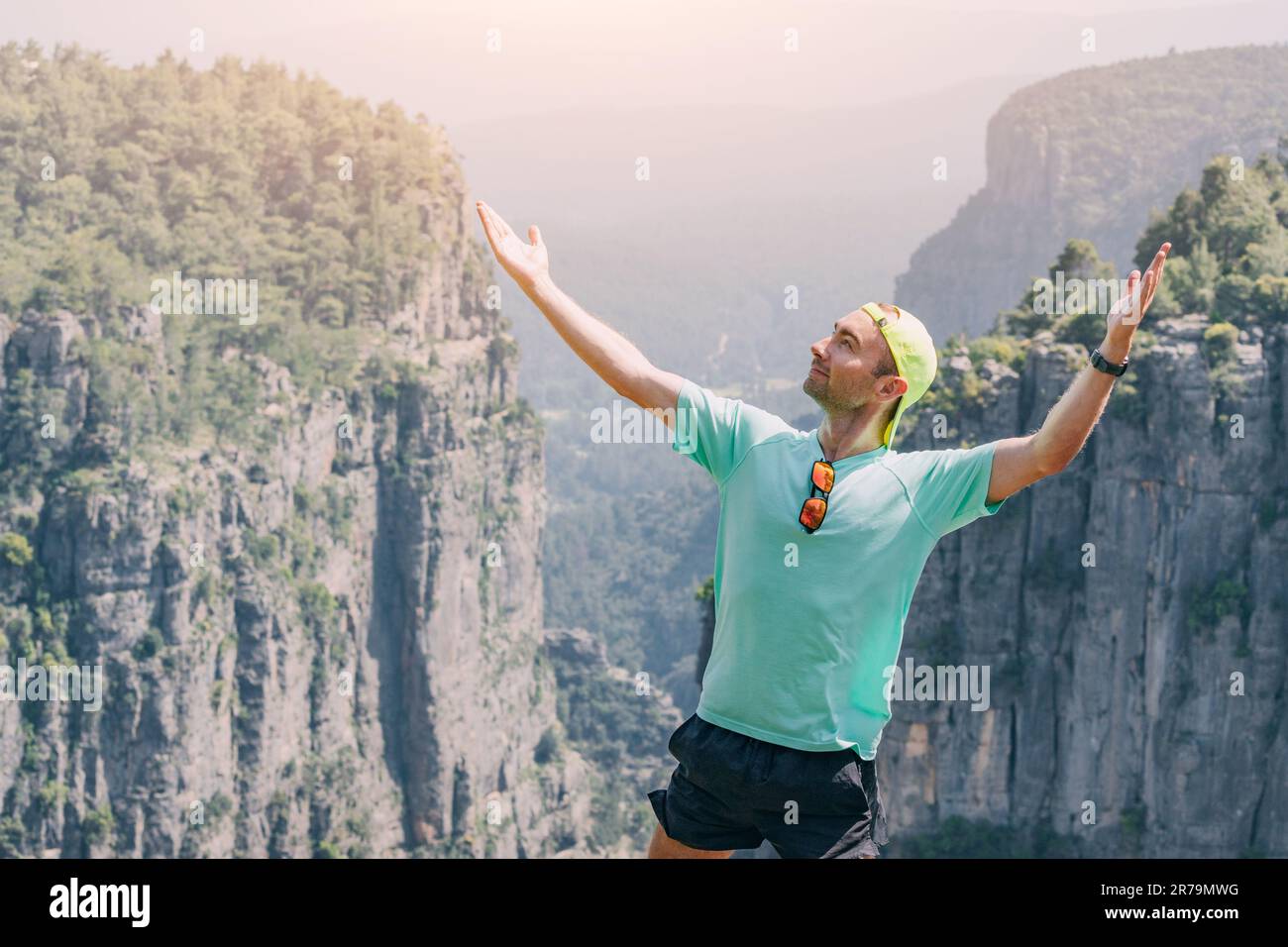 Happy traveler man standing on top of the Tazi canyon in Turkey. Tourist attractions and sky running concept Stock Photo