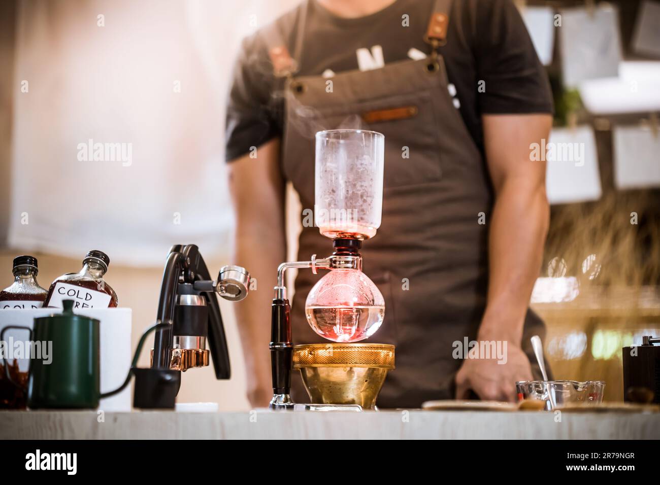 Professional coffee maker Barista using coffee siphon brewing hot